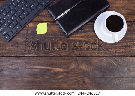 Wooden office table with computer, pen and a cup of coffee, lot of things. Top view with copy space