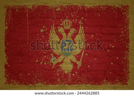 colorful painted big national flag of montenegro on a massive old brick wall