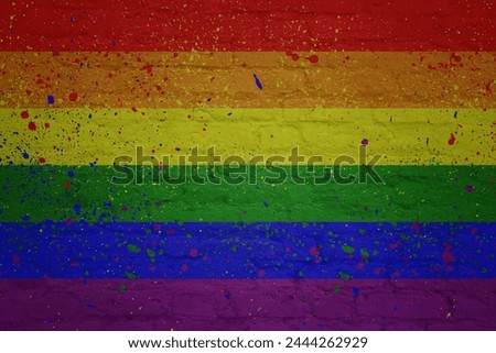 colorful painted big rainbow gay pride flag on a massive old brick wall