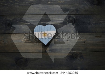 wooden heart with national flag of argentina near reduce, reuse and recycle sing on the wooden background. ecological concept Royalty-Free Stock Photo #2444263055