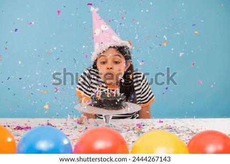 Portrait of little girl blowing out birthday candles
