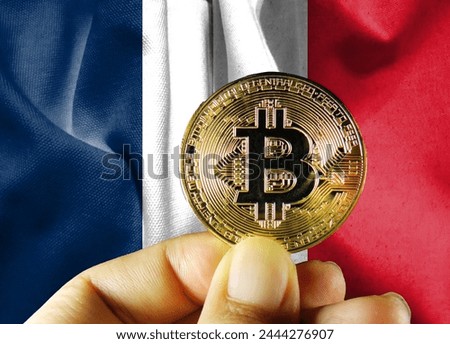 Holding physical Bitcoin (new virtual currency) and French flag. Concept image of French cryptocurrency and blockchain technology investors