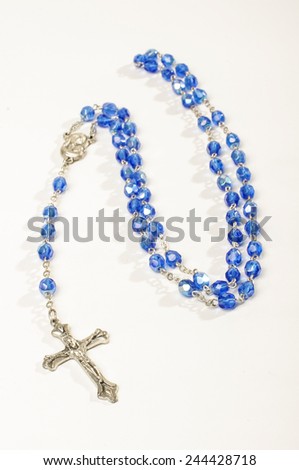 Blue rosary isolated on the bright background