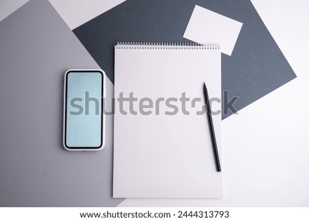 Spiral notepad on the table, business card and laptop. Business, stationery or education concept: image of an open notebook with blank pages