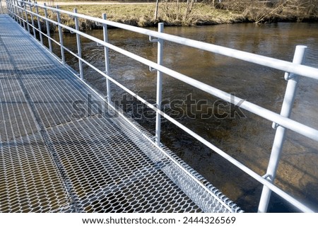 metal bridge for pedestrians and cyclists with a grating base