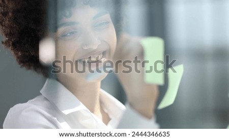 woman working on project plan using sticky papers notes on glass