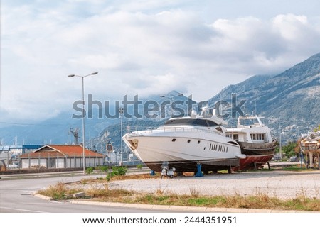 Yachts in repair dock. Motor yacht dry docking Royalty-Free Stock Photo #2444351951