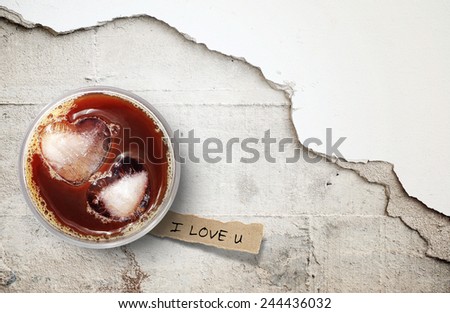 Iced coffee and  torn paper on cracked concrete floor, background for valentine's day.