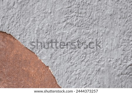 Colorful grey-brown wall surface of an old building with crumbling plaster as a textured background. Copy space. Selective focus. Royalty-Free Stock Photo #2444373257