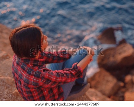 Young woman hiking on rocky beach in Spain, Benidorm. Watching the choppy sea and the bay. traveler enjoying freedom in serene nature landscape Royalty-Free Stock Photo #2444379689