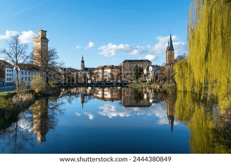 Small pond in Altenburg. Beautiful reflection on the water surface. Art tower, red tips and the tower of the town hall in the picture. Spring weather in Altenburg Thuringia.