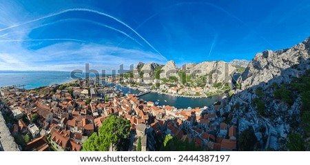 Scenic view of coastal town Omis surrounded by Dinara mountains in Split-Dalmatia, South Croatia, Europe. Majestic coastline of Omis Riviera at Adriatic Sea in Balkans. Travel destination in summer Royalty-Free Stock Photo #2444387197