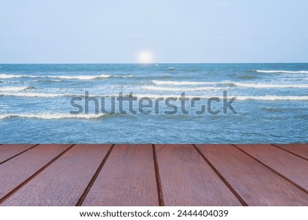 The Empty wooden table and sunrise view with dark blue sea background. For display your products.