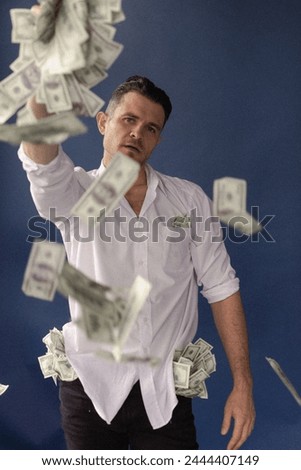 a man in a white shirt throws money left and right, money rains
