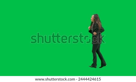 Young female reporter isolated on chroma key green screen background. Full shot african american woman tv news host running. Side view.