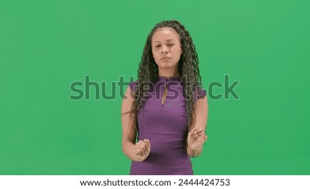 Female in dress isolated on chroma key green screen background. African american woman tv news host uses virtual screen, swiping zooming clicking.