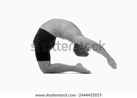 Ashtanga yoga  Side view of man wearing sportswear doing Yoga exercise against white background.  Black and white horizontal image.