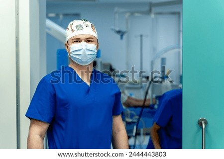 Portrait of handsome doctor in uniform and mask. Medical hospital practitioner.