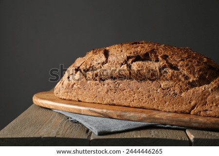 Freshly baked sourdough bread on wooden table, closeup Royalty-Free Stock Photo #2444446265