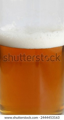 Texture of beer foam covering fresh draft beer in a glass stock photo for vertical backgrounds