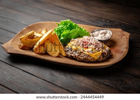 Burger with no bun, cheese and potato patty on dark boards background. Menu for a pub