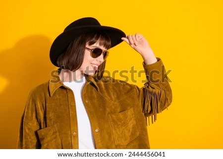 Photo of charming pretty lady wear cowgirl outfit dark glasses arm headwear smiling empty space isolated yellow color background Royalty-Free Stock Photo #2444456041