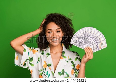 Photo of impressed funky lady wear print shirt hand head rising money fan isolated green color background