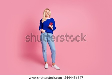 Full size photo of pretty lady use smart phone empty space wear blue sweater isolated on pink color background