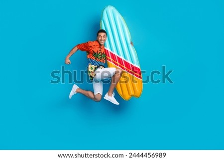 Full body photo of nice young man hold surfboard jump summer holiday isolated on blue color background