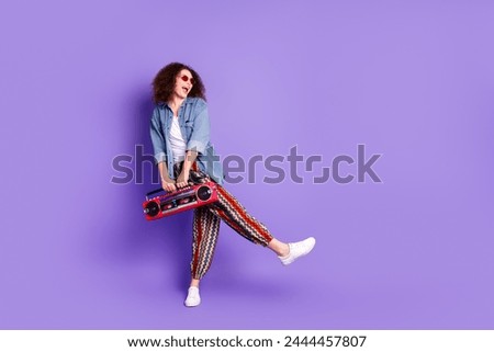 Full size portrait of pretty young woman boombox dance empty space wear denim shirt isolated on purple color background