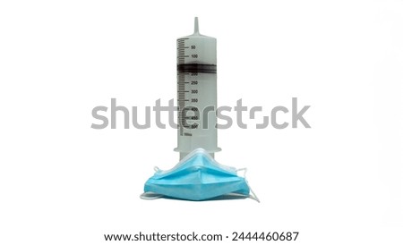 A syringe and a blue surgical mask are placed next to each other. Concept of medical care and attention to hygiene2