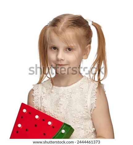 Blonde baby 6 years old, in a white dress shows watermelon