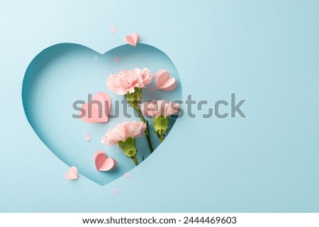 Mother's Day sophistication theme. Top view of lush cloves, hearts, and elegant confetti, displayed within heart-shaped cutout on refined blue background, perfect for conveying thoughtful messages Royalty-Free Stock Photo #2444469603