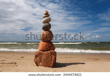 Stone zen pyramid made of colorful pebbles on the beach against a stormy sea. Concept of Life balance, harmony and meditation Royalty-Free Stock Photo #2444474821