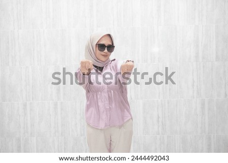 The happy expression of a woman wearing a pink hijab