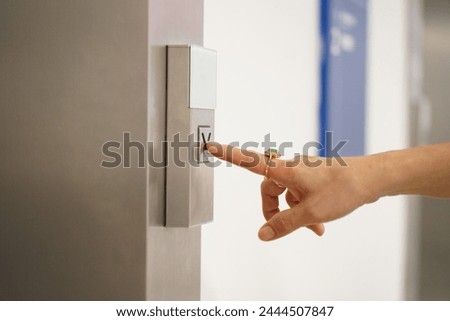 Cropped image, Selective focus on woman finger pressing on elevator button on the wall