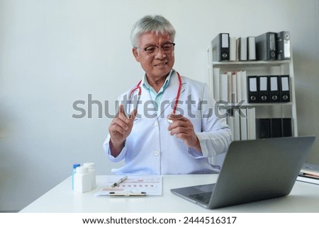 Senior doctor with stethoscope sitting in medical office, treating, recommending medicine. Method of practice Care via laptop Online video calls with patients service concept Disease care.