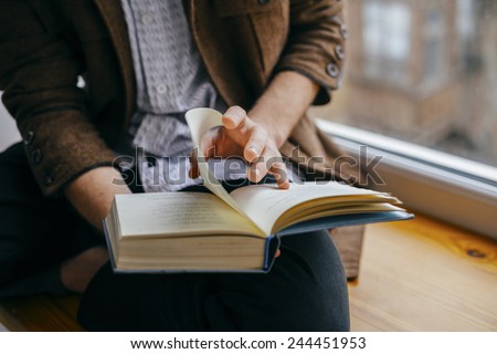 Young man reading a book Royalty-Free Stock Photo #244451953