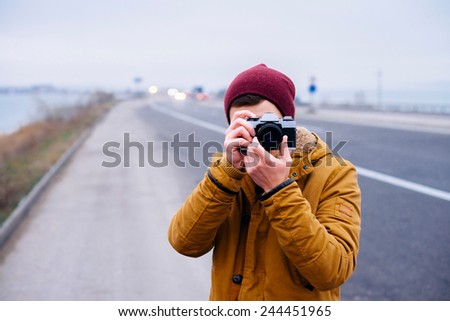 young man photographing on the highway