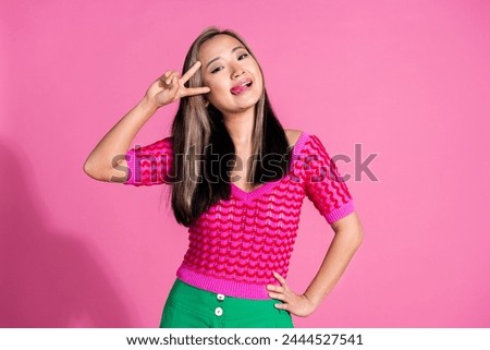 Photo of excited funky lady dressed knitted shirt stick out showing v-sign cover eye isolated pink color background