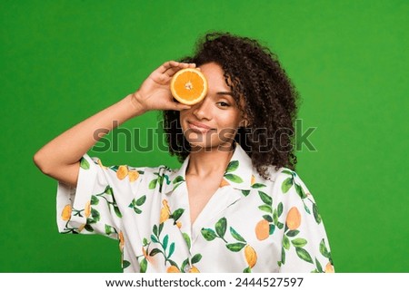 Photo of sweet adorable lady wear print shirt holding citrus half cover eye isolated green color background