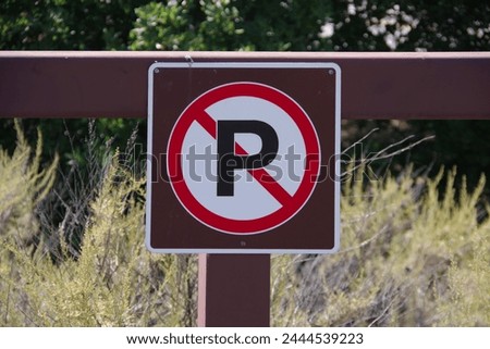 NO PARKING sign on wooden outdoor barrier