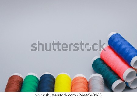 Set of different colorful sewing threads on a gray background. With space for text.
