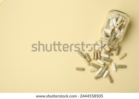 Vitamin pills and bottle on beige background, top view. Space for text