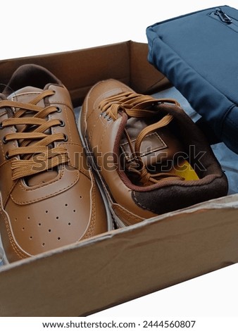 Brown vintage shoes with a black sling bag in the brown card box isolated in a white background