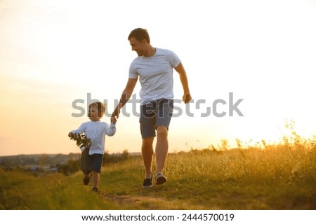 Father's day. Happy family father and toddler son playing and laughing on nature at sunset.