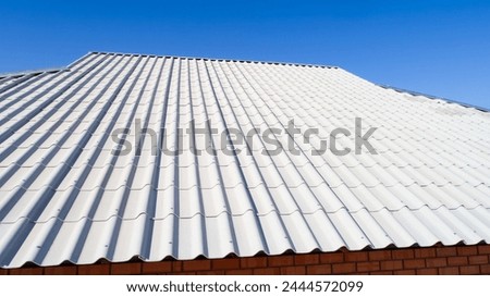 Modern roof. Roof covering. Roman profile. The roof of the house is covered with wavy gray tiles Royalty-Free Stock Photo #2444572099