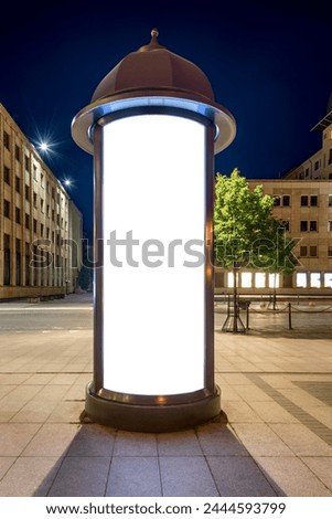 Round Advertising Poster Stand Mockup. Retro Style Illuminated Billboard In A City Square At Night