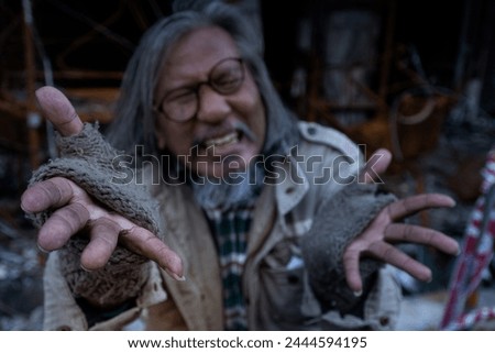 Old man showed signs of madness like a madman when he saw his house destroyed by fire, homeless old man in front of a building destroyed by fire, selective focus Royalty-Free Stock Photo #2444594195
