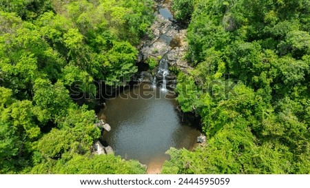 Aerial view of waterfall, natural forest and mysterious trees and mountains. The waterfall has water flowing from the cliff.The rich natural ecosystem of the rainforest concept is about conservation 